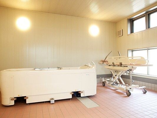 ストレッチャータイプのリフトが右に、左には浴槽タイプの機械があり、明るい雰囲気。