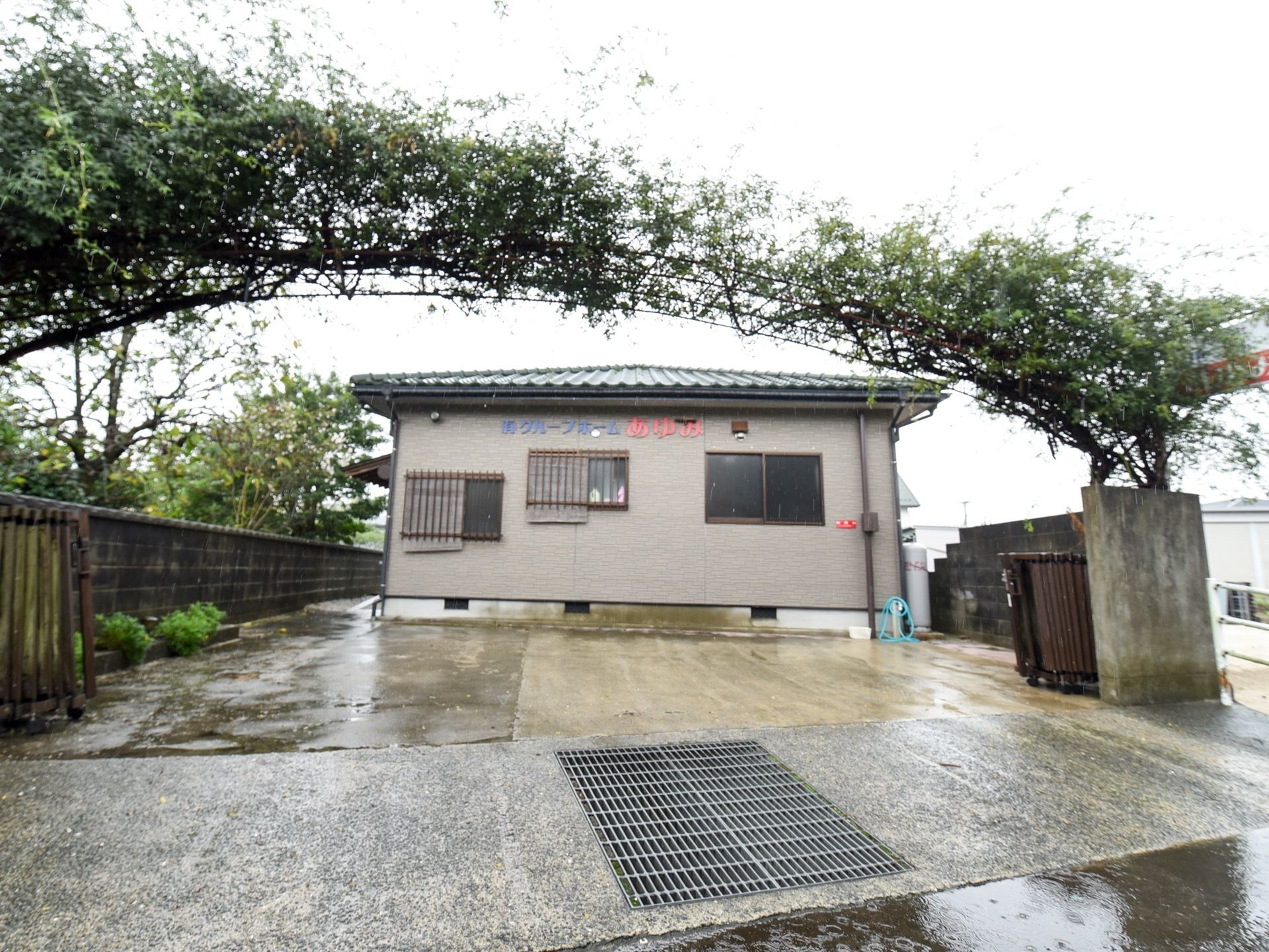 グレーの外壁の建物になっており、平屋建てである。門のところには、印象的な木で形作られたゲートがある。
