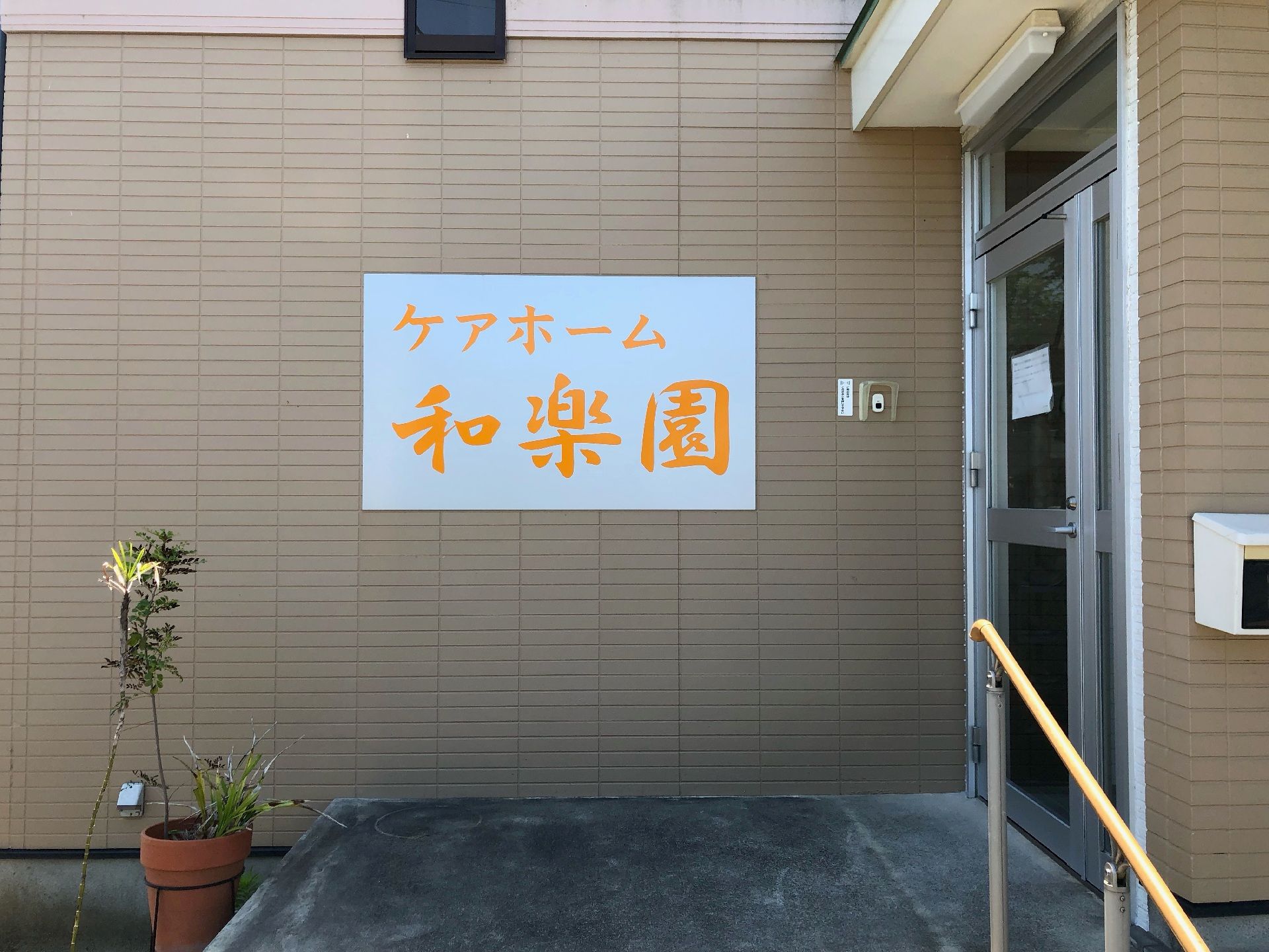 なにかを指さして笑顔で話している車いすの女性とそれを押している介護スタッフの様子