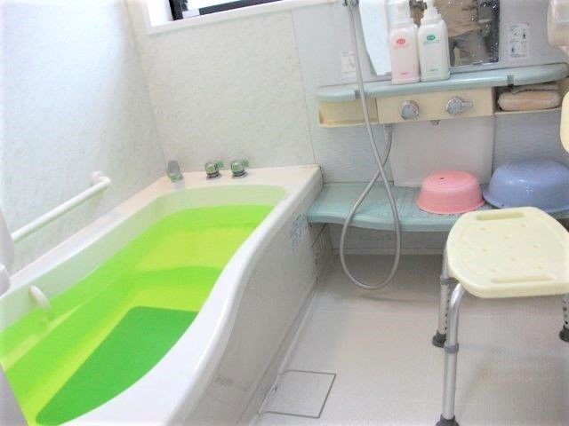 家庭用サイズの浴室の様子。シャワーチェアや手すりが取り付けてあるのが分かる