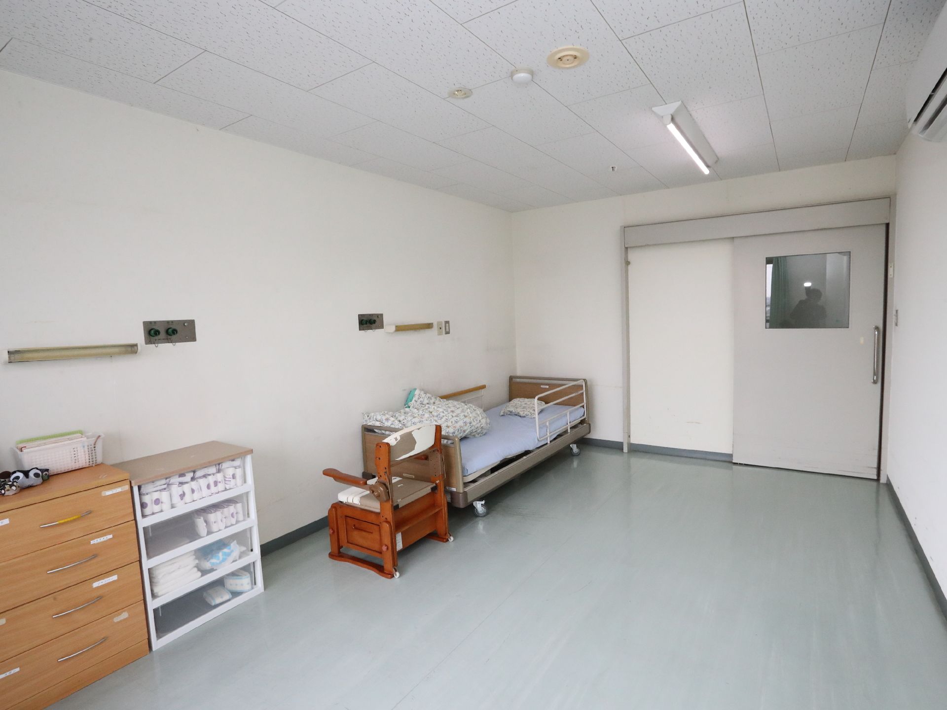 介護ベッドが設置され、家具や車椅子が置かれている居室