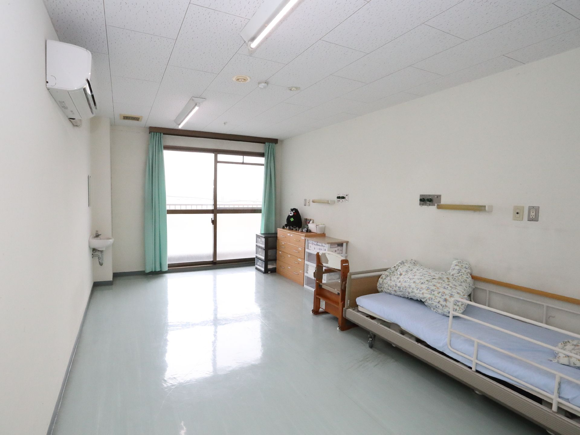 窓から日差しが注ぎ、介護ベッドが置かれている居室