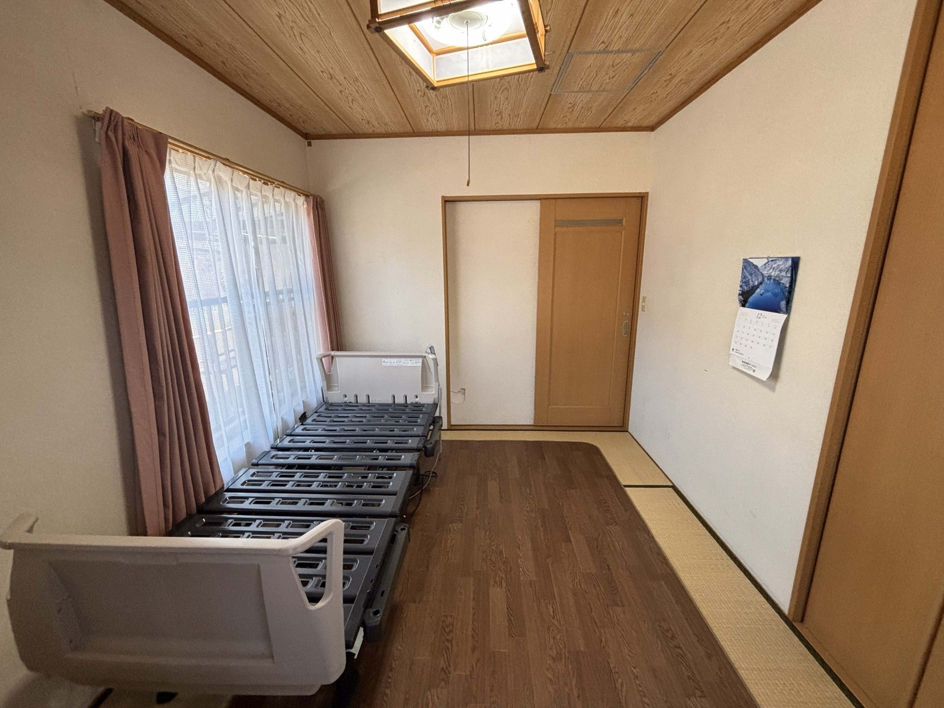 窓際のベッドと畳の部屋