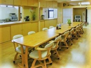 ４人掛けのダイニングテーブルが複数つなげて並べられた食堂はキッチンが対面式。