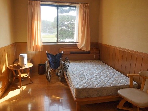ベッドやテーブルセットが置かれた居室はフローリングで日当たりもよく、居心地のよさそうな雰囲気。