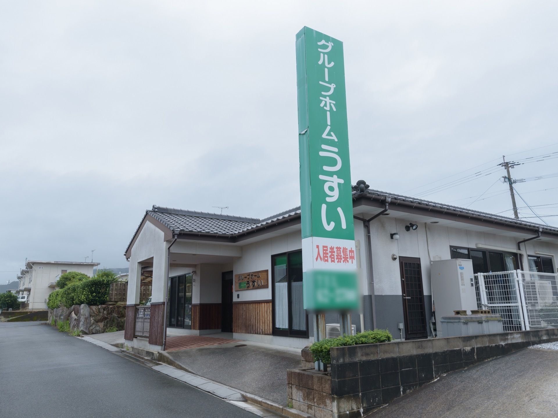 白い漆喰の壁に瓦屋根が乗った建物で、１階建ての平屋造りである。施設の前には緑色の大きな看板が立っている。