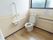 開放的なトイレである。窓が設置されており、壁紙には花が描かれている。L字型の手すりが備えてある