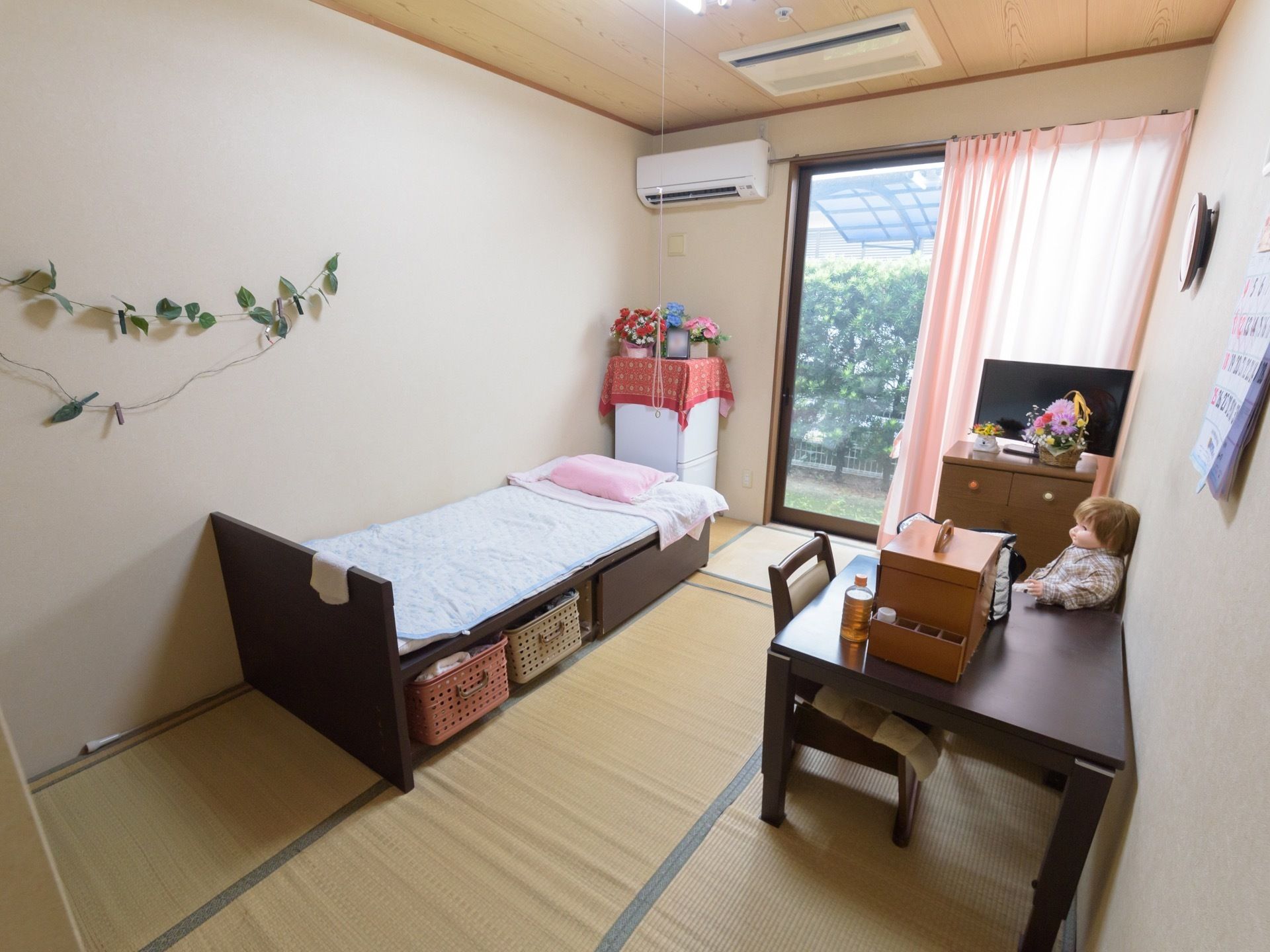 床が畳の居室である。ベッドや机が設置されており、窓にはカーテンが掛けてある。生活に必要な家電が揃っている。