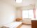 エアコンが付いた部屋には介護ベッドが設置され、タンスもある。大きな窓にはカーテンが付いている。