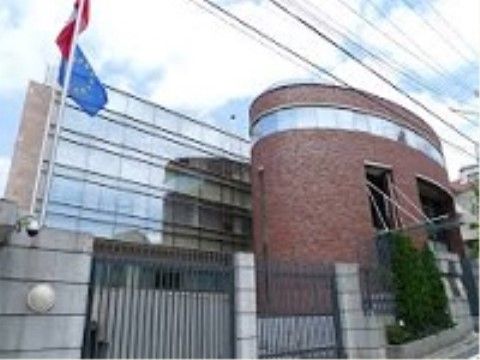 大使館の門の内側には、ポーランド国旗とEU旗が取り付けられたポールが設置されている。円柱型の建物が特徴的である。