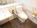 洋式トイレの床は黒に近い色で、一か所赤いダイヤの形の模様が入っている。手すりは、可動式と固定されたものが付いている。
