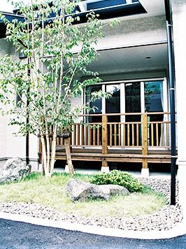 施設のウッドデッキを外側から写した写真。手前に中庭がある雰囲気胃の良い場所