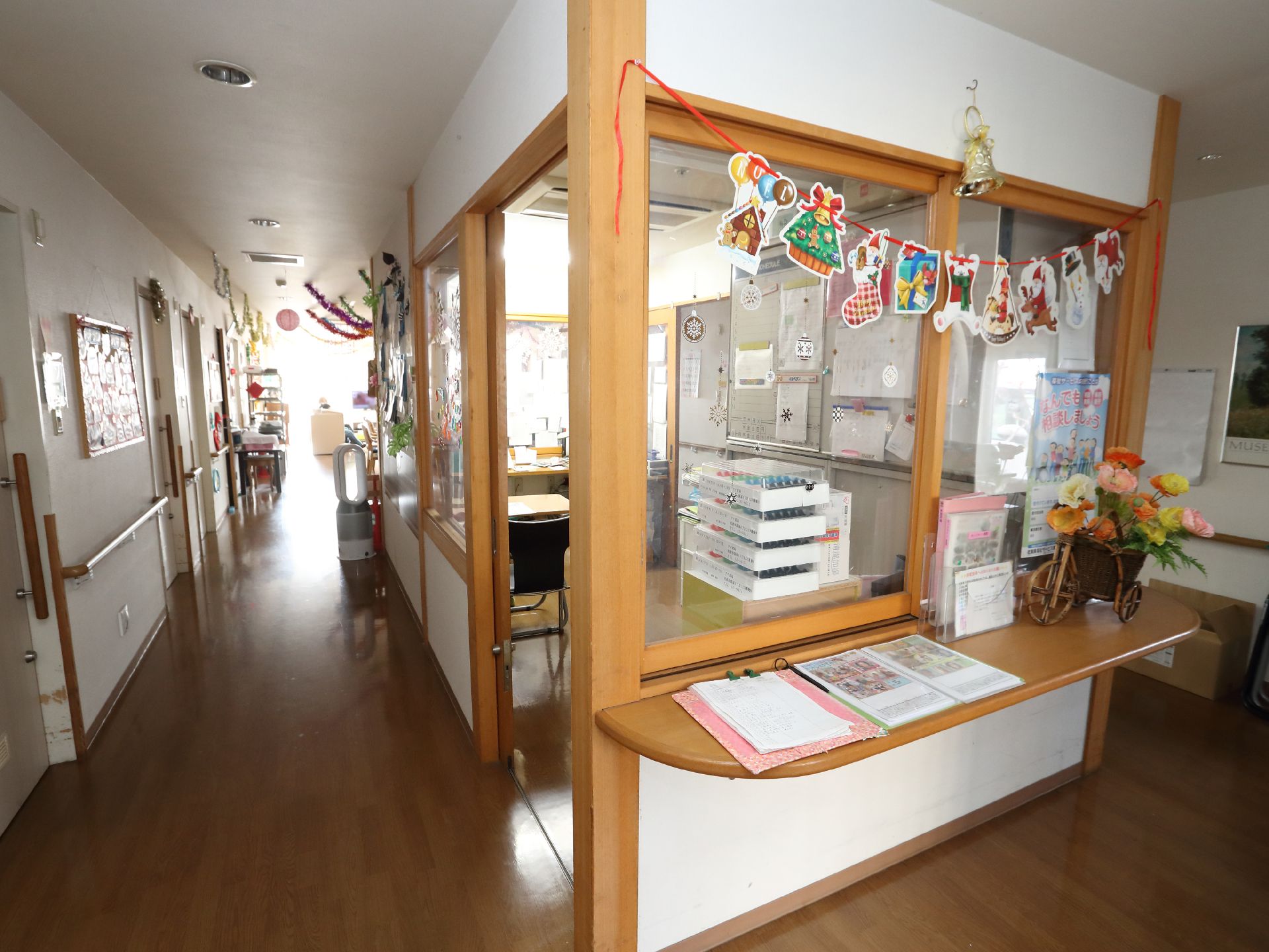 からだを動かしている高齢女性と男性スタッフの様子。施設内で体操しているときの一場面