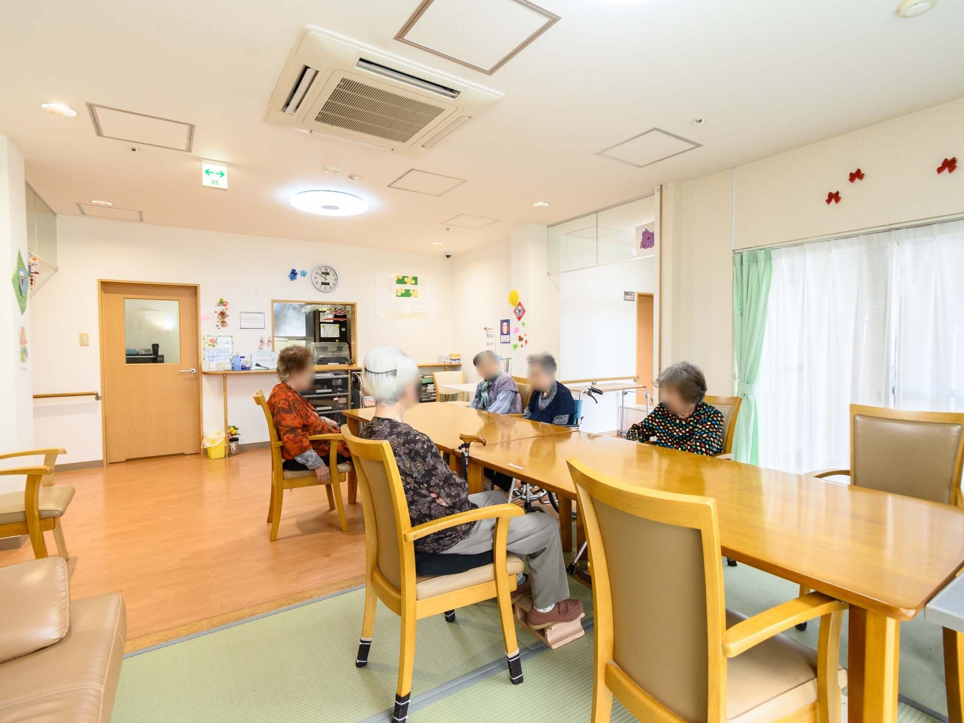 木製のテーブルと椅子が設置された共有スペース