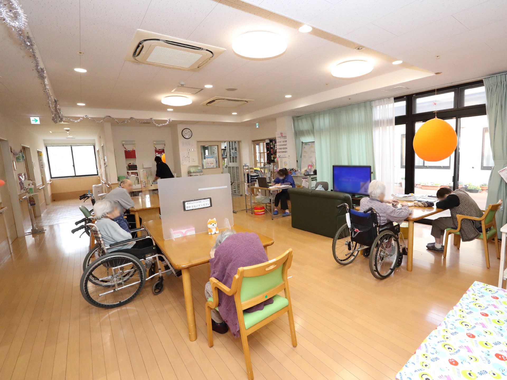 フローリングの部屋には大きな窓があり、介護ベッドやタンスが置かれている。