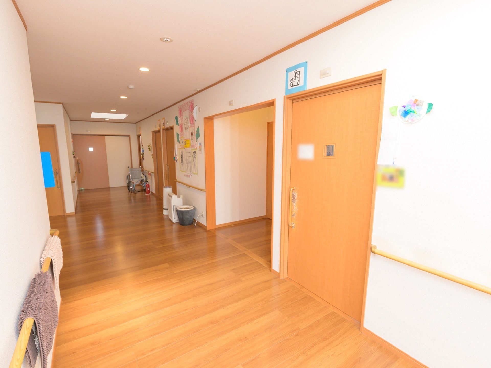 通路幅が広く、壁には手すりが備えつけられている。扉はスライド式になっており、壁には制作物がレイアウトされている。