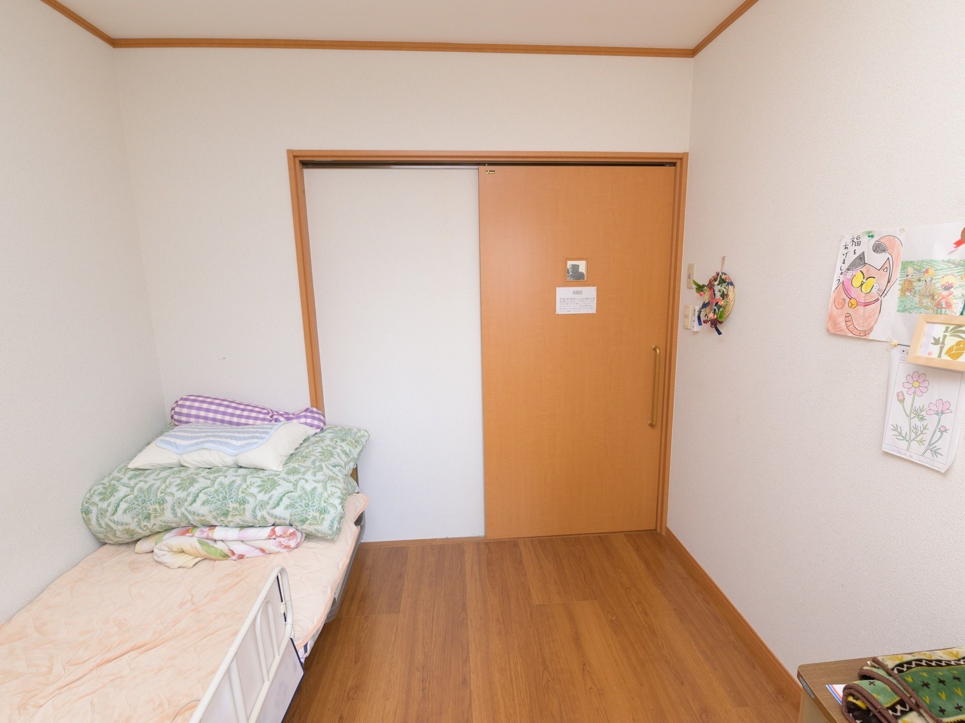 白を基調とした落ち着いた部屋になっており、床はフローリングになっている。介護用ベッドが置かれている。