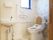 背もたれ付きの便座があるトイレには手すりや呼び出しボタンも設置され、手洗い場もある。