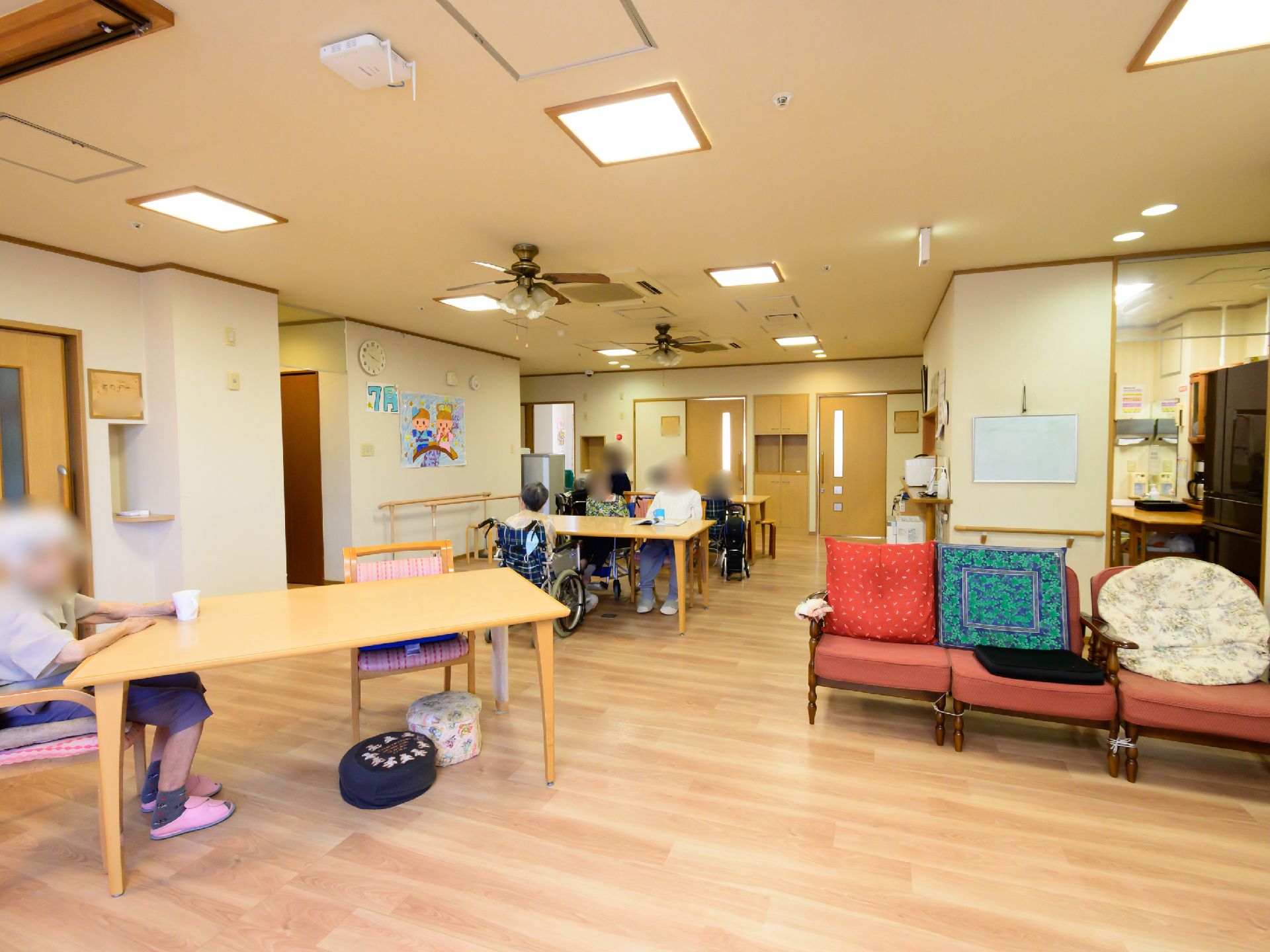 テーブル、椅子が設置され、入居者が自由に時間を過ごしているリビング