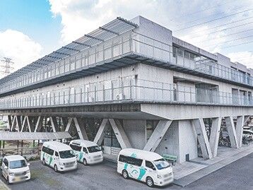 送迎車が並ぶ建物外観