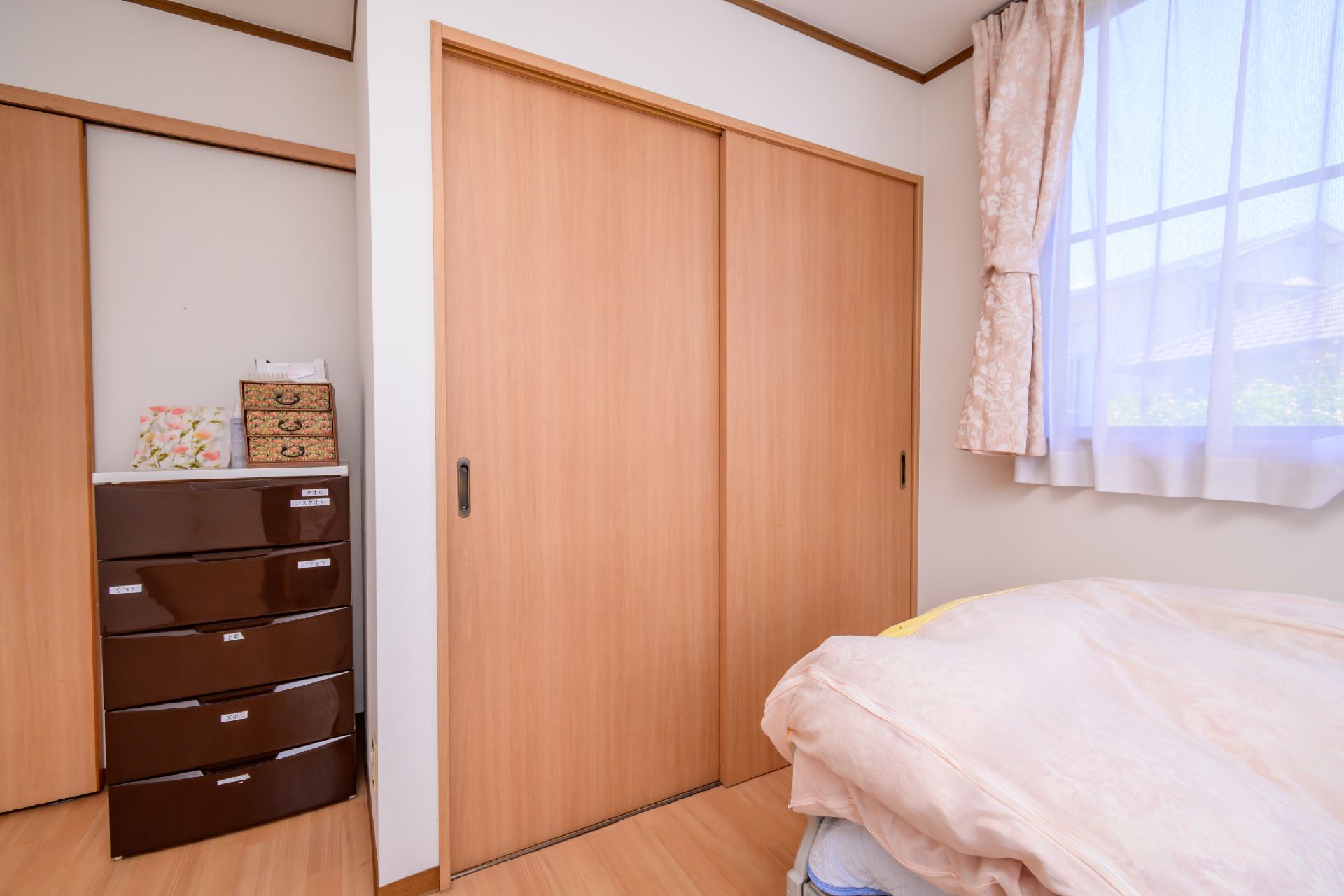 介護ベッド、収納がおかれ、窓から光が注いでいる居室