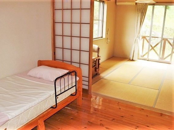 畳とフローリングの部屋があり、広々としている。ベッドなどの家具もある。