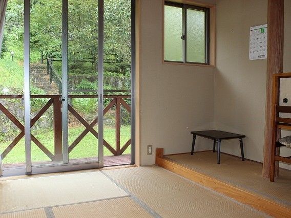 床の間には収納スペースもあり、小さなテーブルが置かれている。ウッドデッキ付きの部屋。