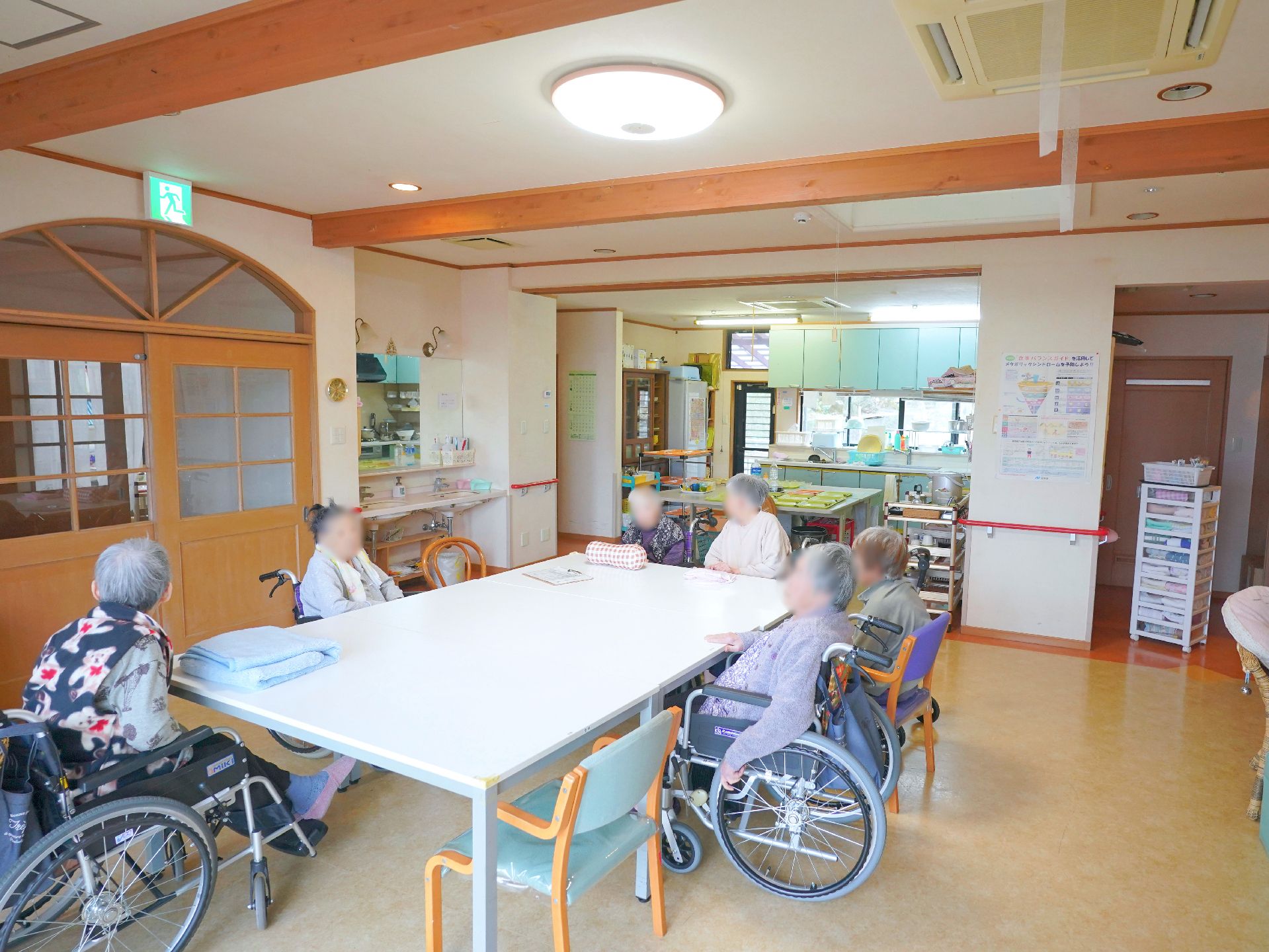 介護車両で外出する車椅子に乗った高齢の男女と介助をするヘルパー