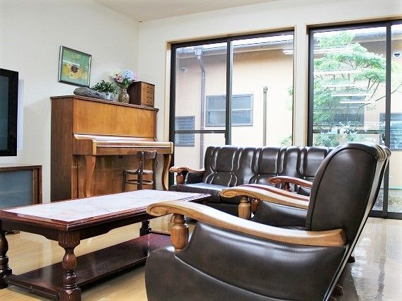 リビングにはソファやテレビ、ピアノが置かれ、窓からは庭園を見ることができる。
