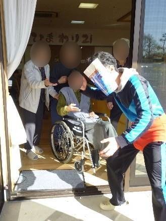 豆まきの様子。鬼に扮したスタッフとそれを見ている高齢者が見える。