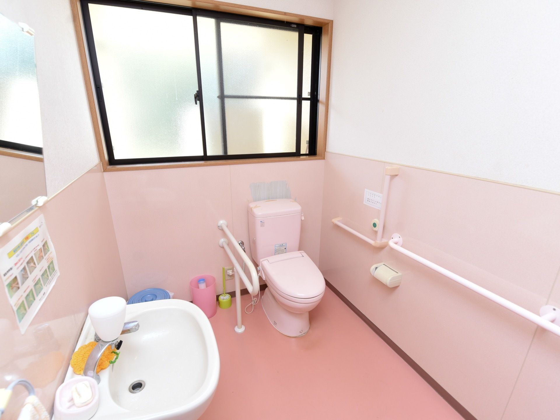 トイレは壁の一ヶ所が横幅いっぱいに開く窓になっている。窓の下に便座があり、壁には手すりが取りつけられている。
