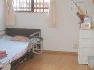 ひとり用のシンプルなお部屋。介護用ベッドやちょっとした収納などが並んでいる。