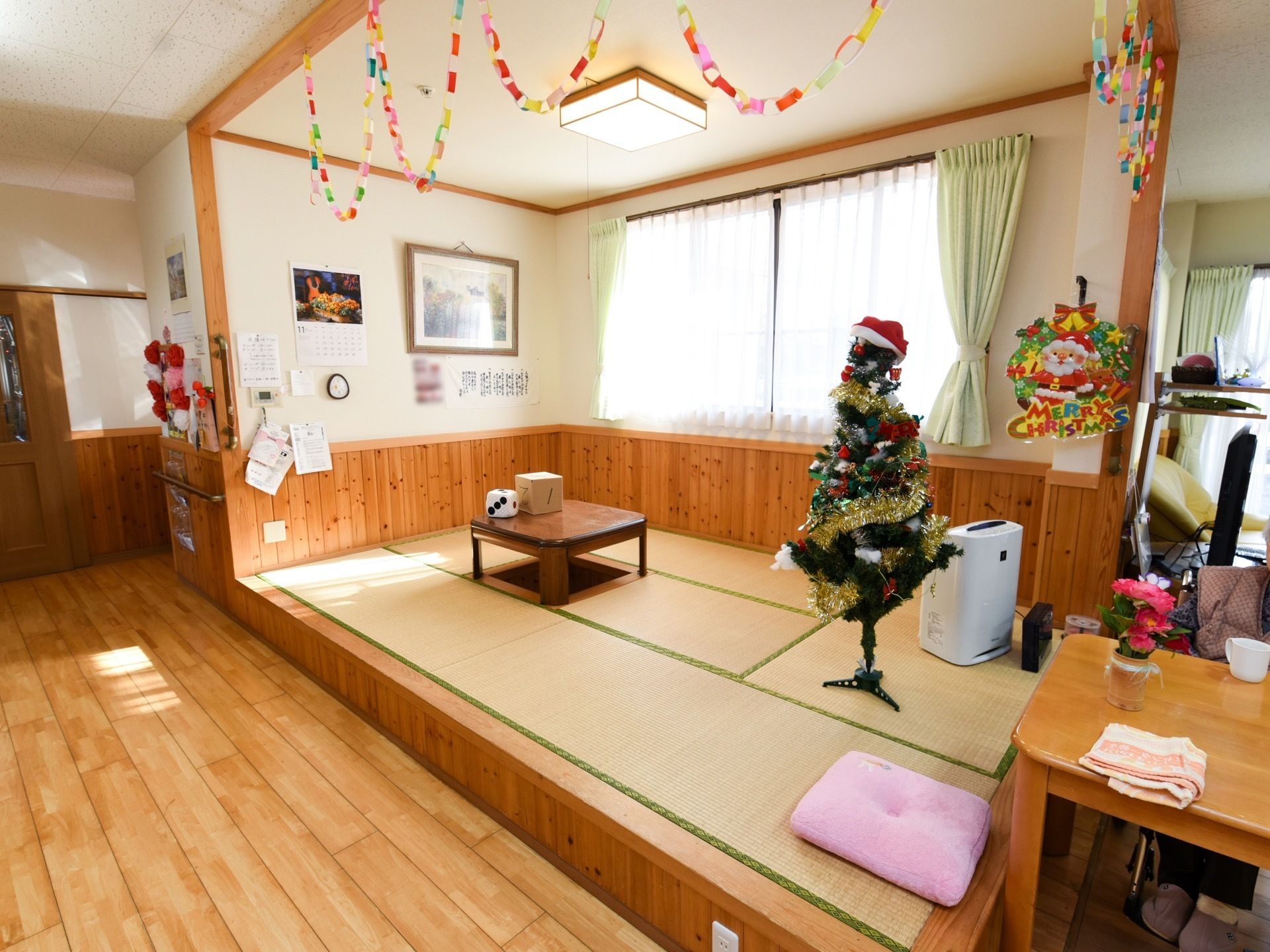 小上がりになったスペースは畳敷きの和室になっている。ちゃぶ台や空気清浄器があり、クリスマスツリーが飾られている。