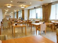 ダイニングルームでは、2人の女性の入居者様が向かい合い食事されている。奥には1人で食事する男性の入居者様の姿が見える。