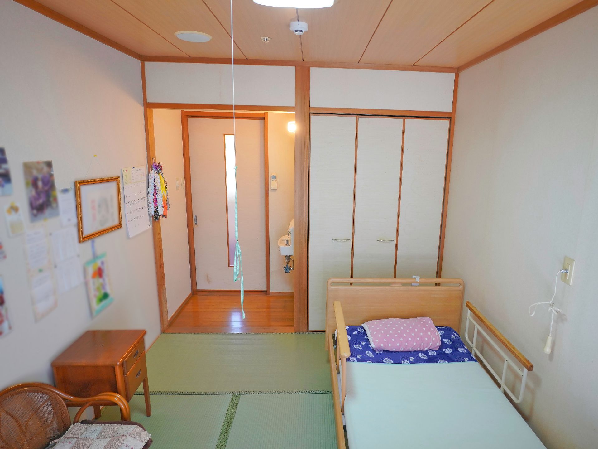介護ベッド、収納棚などが置かれ、窓から日差しが入っている居室