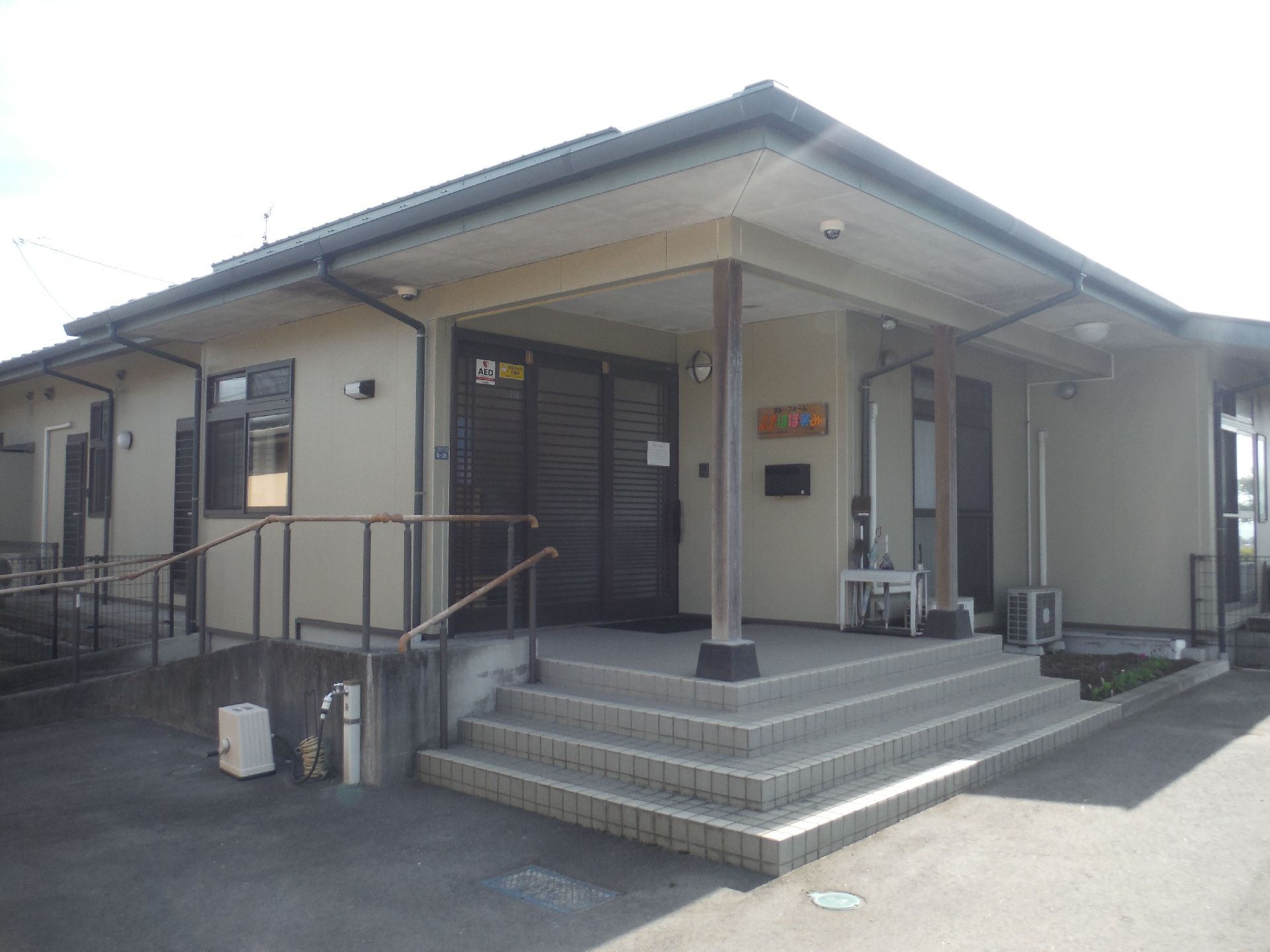 玄関前に階段とスロープが設置された施設外観