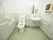 洗面台が備え付けられている広々とした個室トイレである。壁には、手すりや操作パネルがある。