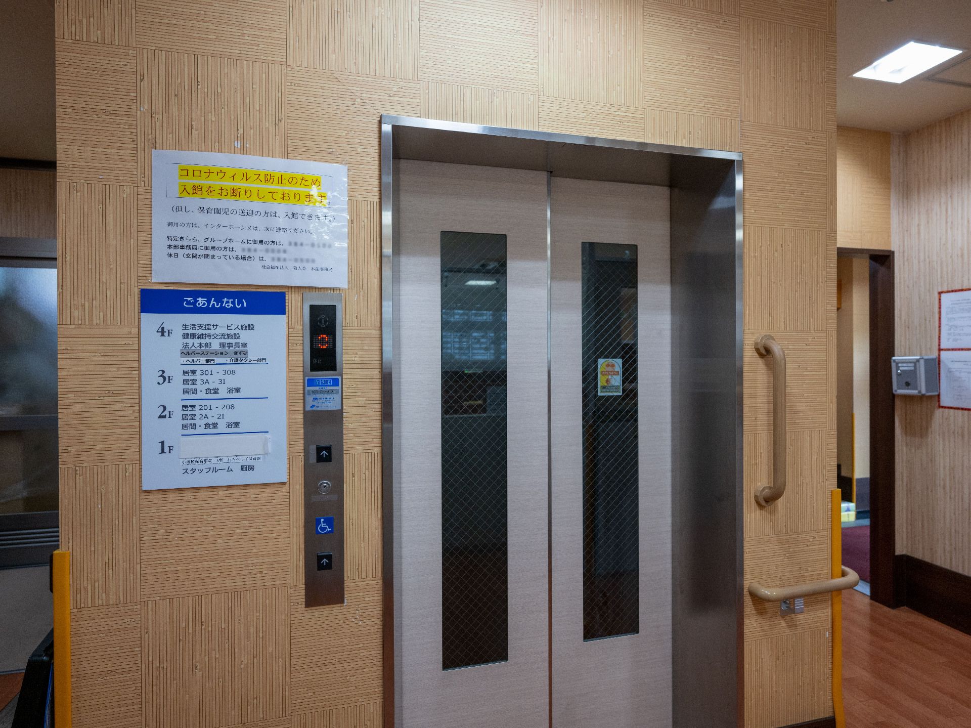 ブラウン色の壁に設置された白いエレベーター