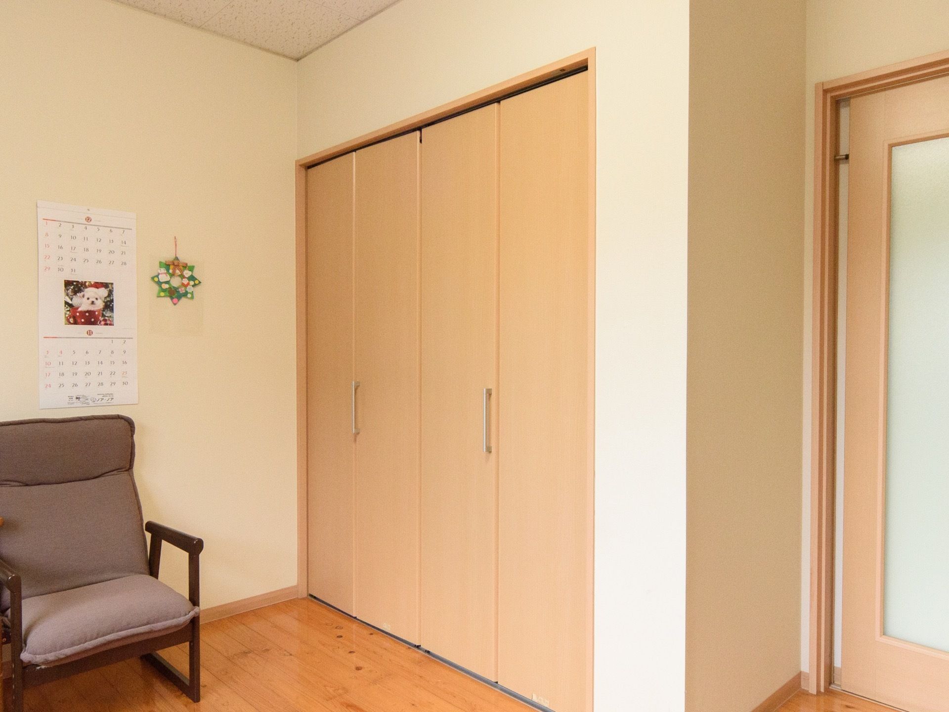 居室入口は大きなすりガラスの入った引き戸である。入口のすぐ近くに、観音開きの扉がついた背の高い収納スペースがある。