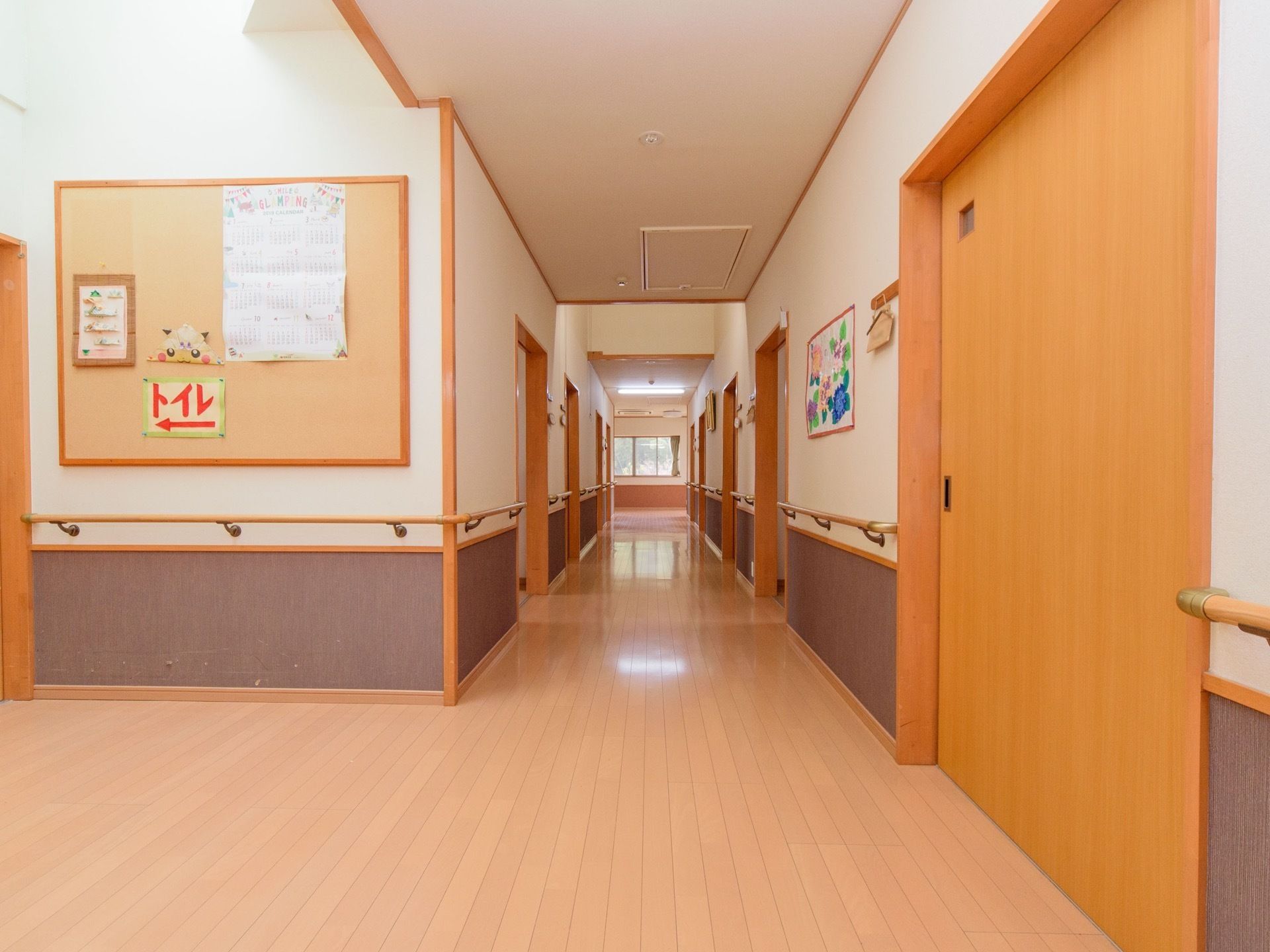 広々とした通路の床はフローリングとなっている。壁には手すりが設置されており、天井が高く、開放感がある。