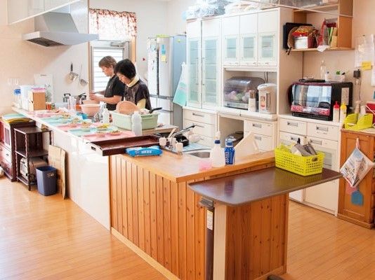 オール電化のキッチンでスタッフが2名作業している。対面式で作業台も広い。