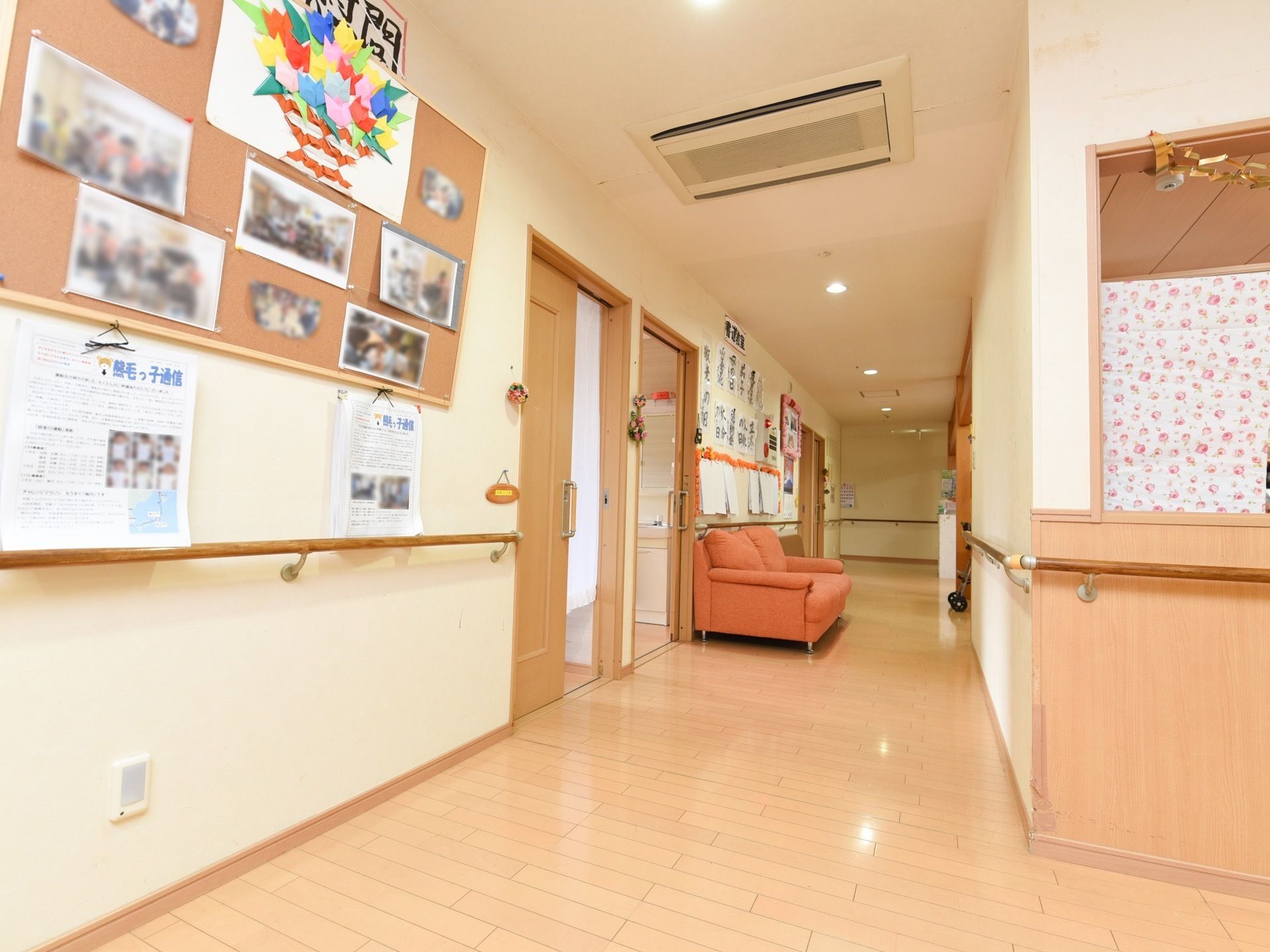 幅が広く明るい廊下である。両サイドに沿って手すりが取りつけられており、２人掛けソファが壁際に配置されている。