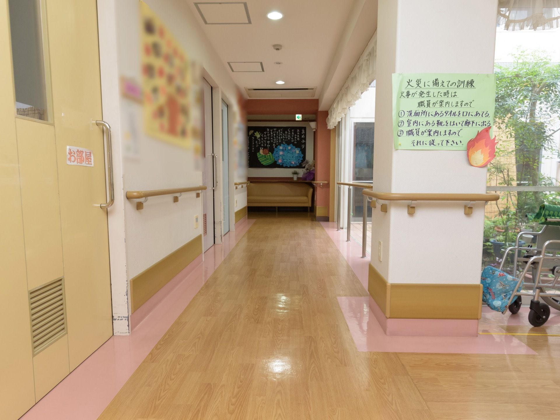 見通しの良い明るい廊下である。壁や柱には、手すりが取り付けられている。ソファが奥の壁際に置かれている。