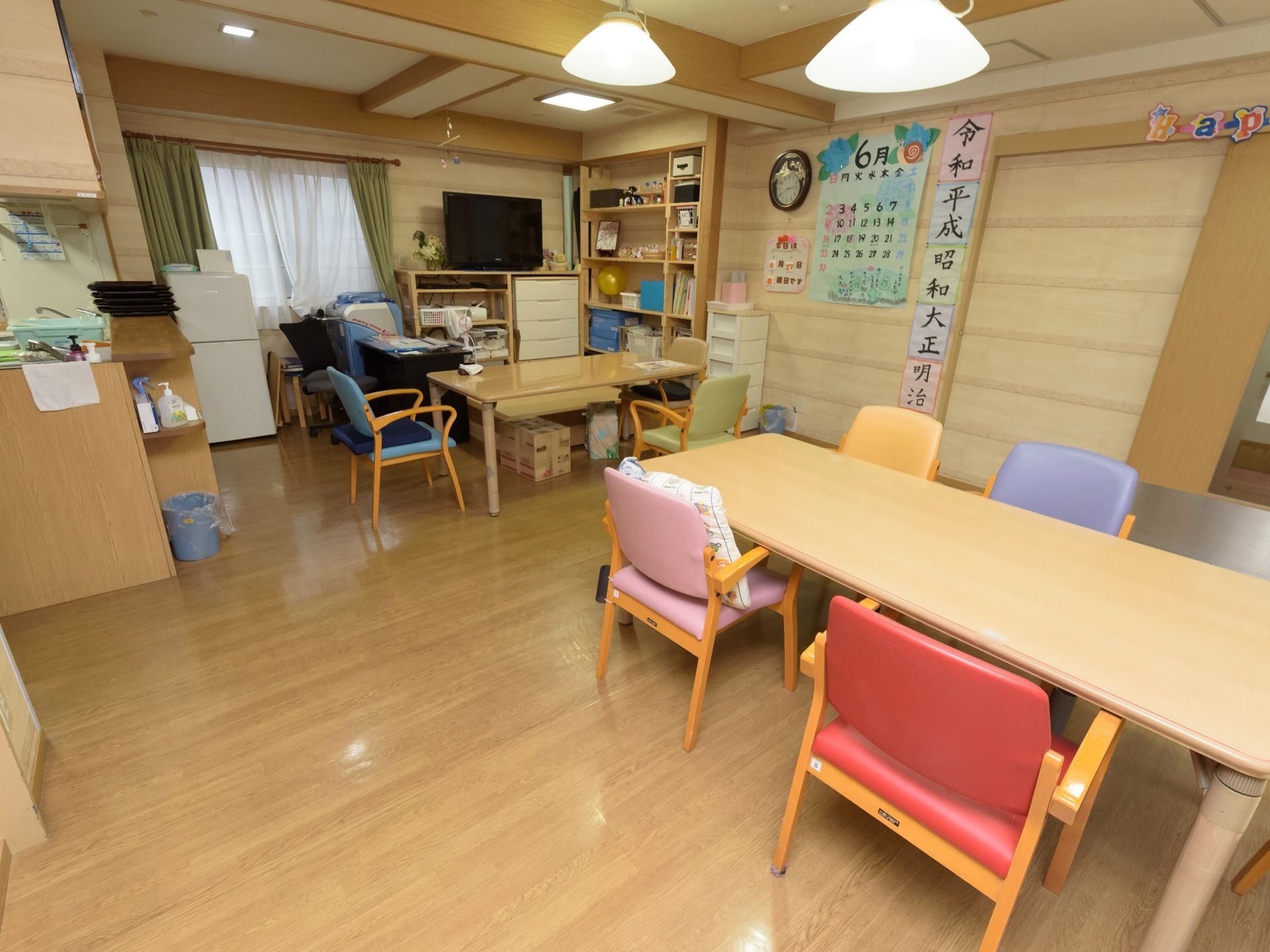 明るく温かい雰囲気の食堂である。左奥に対面式キッチンが設けられており、椅子のあるダイニングテーブルが置かれている。