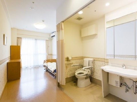 カーテンで仕切られたトイレと洗面台が設置された居室