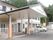 緑に囲まれた環境の中に建っている白を基調とした2階建ての建物。玄関には大きな車寄せが付いている。