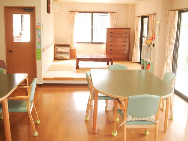 大きな窓が付いた畳の小上がりにはタンスやちゃぶ台が置かれ、リビングダイニングにはテーブルセットが置かれている。