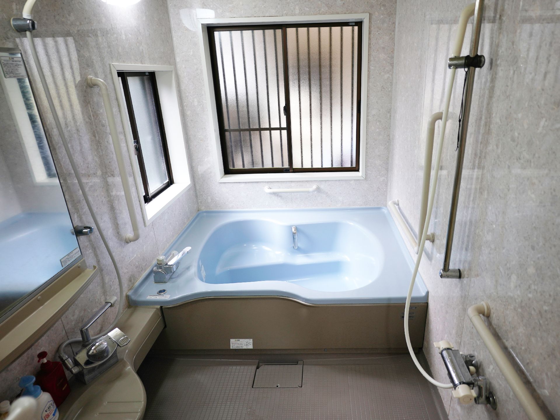 手すりが設置され、床に滑りにくい床材が使用されている浴室