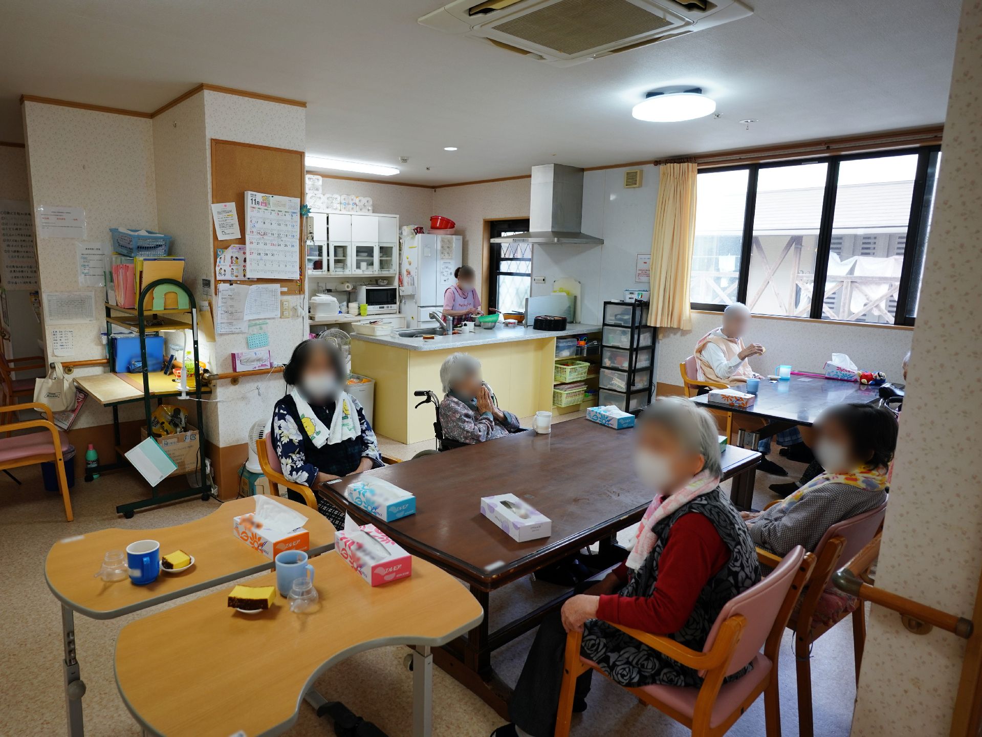 窓から日差しが降り注ぐ椅子とテーブルのある共有スペース