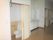 引き戸が設置されたトイレが廊下の一角にあり、便座のふたが上げられている。横の壁には手すりが設置され、スペースが広い。